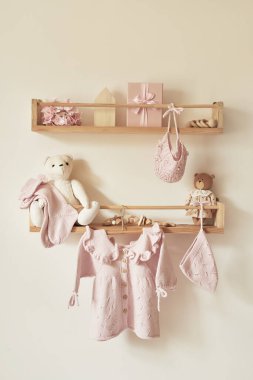 Askıya asılmış çocuk örgüsü. Ceket, kazak, şapka, ayakkabı. Oyuncaklar. Çocuk odası, çocuk odası..