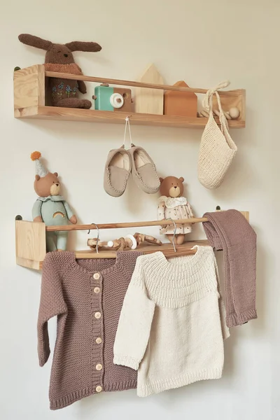 Askıya asılmış çocuk örgüsü. Ceket, kazak, şapka, ayakkabı. Oyuncaklar. Çocuk odası, çocuk odası..