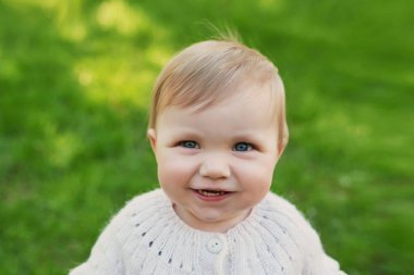 Parkta çimlerin üzerinde gülümseyen bebek. Çocuk Koruma Günü. Dünya Çocuk Günü.