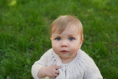 Parkta çimlerin üzerinde gülümseyen bebek. Çocuk Koruma Günü. Dünya Çocuk Günü.