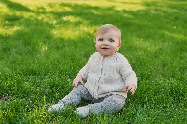 Parkta çimlerin üzerinde gülümseyen bebek. Çocuk Koruma Günü. Dünya Çocuk Günü.
