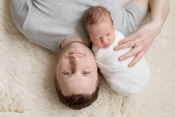 Newborn baby in mother's arms on bed. Postcard Mother's Day and Easter. Children Protection Day. World Happiness Day. Smiling child and man.