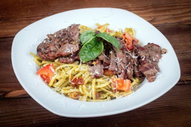 Grilled flank steak over basil pesto and tomato keto pasta dish