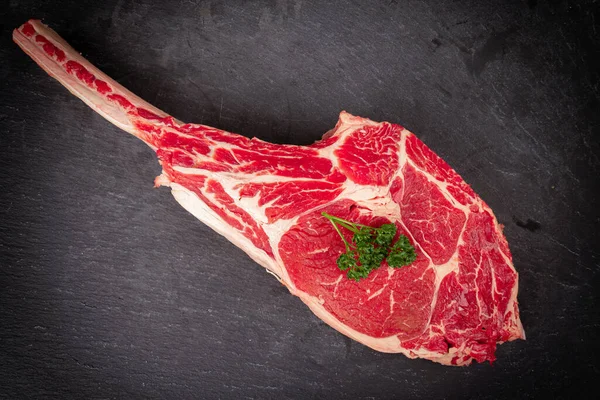 Rauwe Tomahawk Steak Leisteen Achtergrond Met Peterselie Kruid Voor Het — Stockfoto