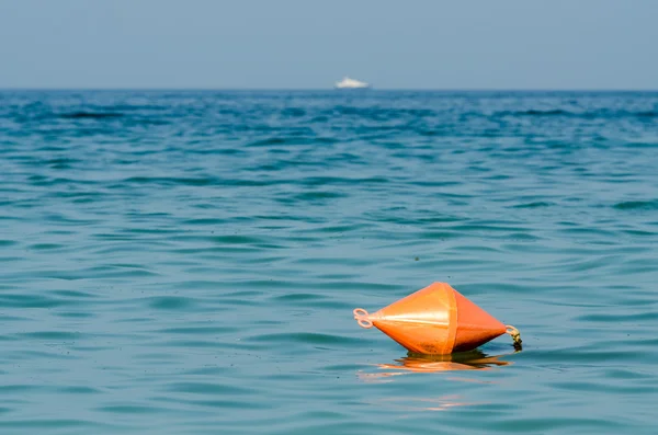 Oranje leven boei in oceaan met schip in zicht — Stockfoto