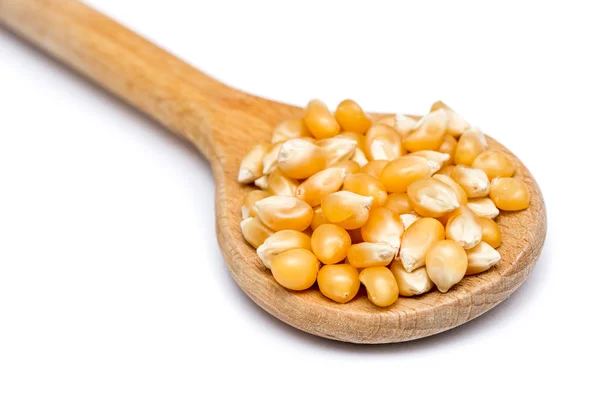 Cuchara de madera con semillas de maíz en blanco — Foto de Stock