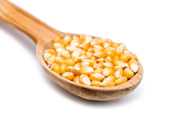Cuchara de madera con semillas de maíz en blanco — Foto de Stock