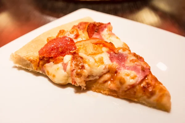 Пицца ломтик подается в ресторане — стоковое фото