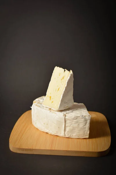 在深色背景的木板上 用柔软的法式Brie奶酪贴合着芝士板 三角芝士与 健康的开胃菜 开胃菜 小吃或甜点 — 图库照片