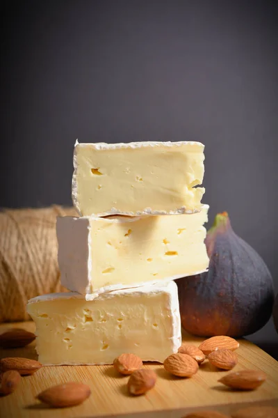 法式奶酪的侧面视图 奶酪板与软奶酪片 Platter Served Almond Nuts Fig Fruit Wooden Background — 图库照片
