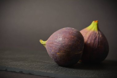 İki Azerbaycan incir meyvesinin üst görüntüsü. Egzotik doğu meyvesi. Asyalı böğürtlen siyah taş arka planda izole. Tek bir nesne. Boşluk resmini kopyala