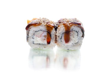 İki parça Japon suşisi, üstünde yılan balığı dilimi ve susam tohumlu unagi sosuyla servis ediliyor. Yengeç eti çubuğu, Ebi karidesi, içinde krem peynir. Beyaz arkaplanda dışa dönük rulo.