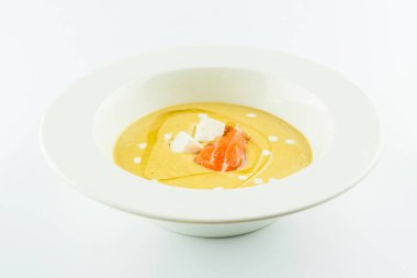 Tütsülenmiş somon ve zeytinyağıyla servis edilen Feta peynirli sebze püresi çorbası. Beyaz arka planda izole edilmiş ilk kremalı çorba..