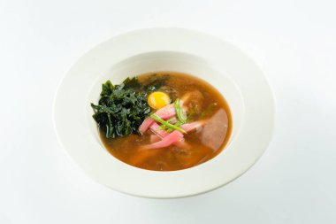 Beyaz zemin üzerinde servis edilen ton balığı filetosu, karabuğday eriştesi, bıldırcın yumurtası, yosun ve yeşil soğanlı Asya Miso çorbası. Uzay resmini kopyala. Tayland yemeği.