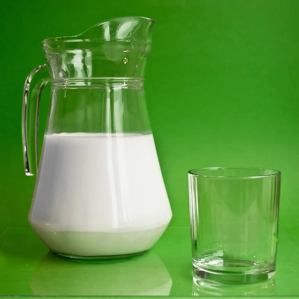 Jarra de vidrio con leche y un vaso — Foto de Stock