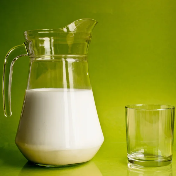 Jarra de vidrio con leche y un vaso — Foto de Stock