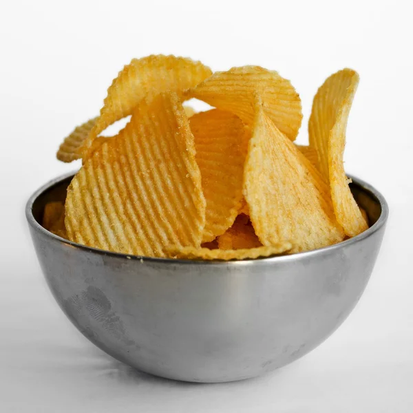 Metallschale voller welliger Kartoffelchips, auf weißem Hintergrund — Stockfoto