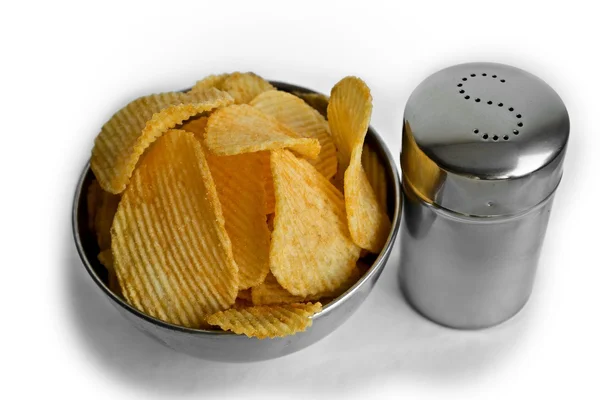 Metallschale voller Chips neben einem Salzstreuer aus Stahl, auf weißem Hintergrund Stockfoto