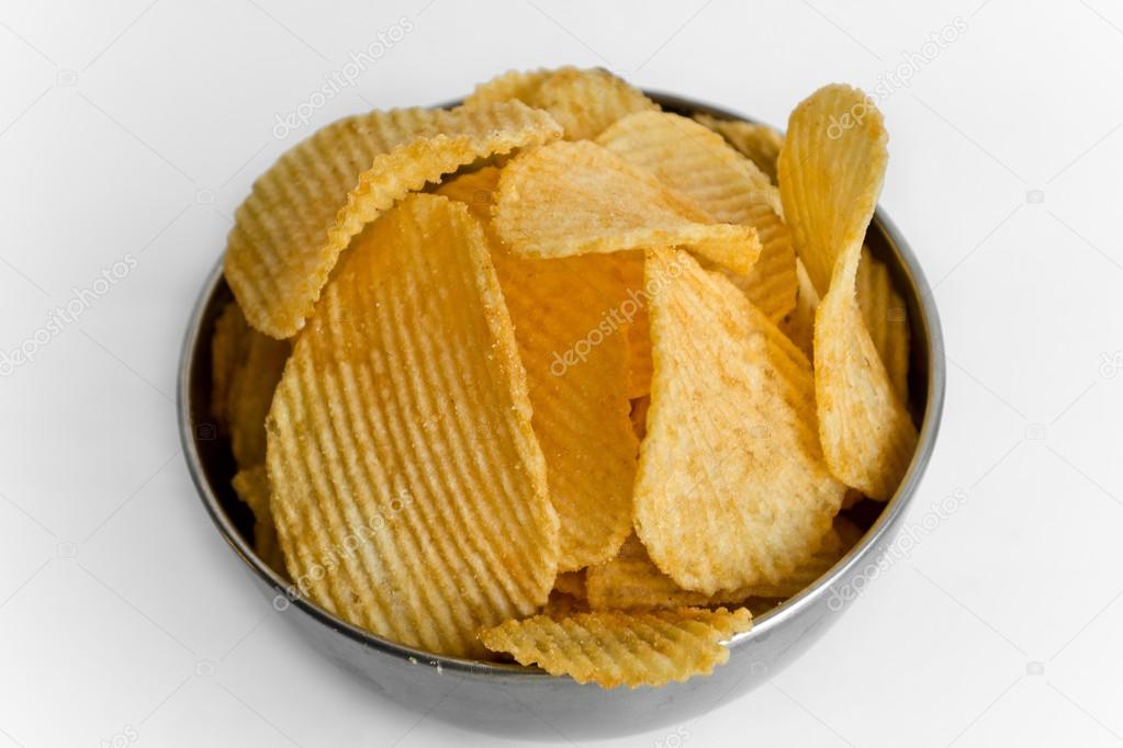 Metal bowl full of wavy potato chips, on white background