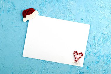 Çarşafın üst köşesindeki mavi bir yüzeye beyaz bir çarşaf dikilmiş. Alt köşedeki Noel Baba şapkası, kalp şeklinde katlanmış şekerler. Noel Baba 'ya yeni yıl dilekleriyle birlikte yazılmış kavramsal bir mektup. Yüksek kalite fotoğraf