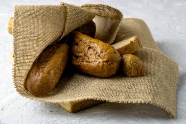 Çuval bezi üzerinde iki taze çavdar ekmeği. Çöreklerden biri bıçağın yanında kesilmiş. Yüksek kalite fotoğraf