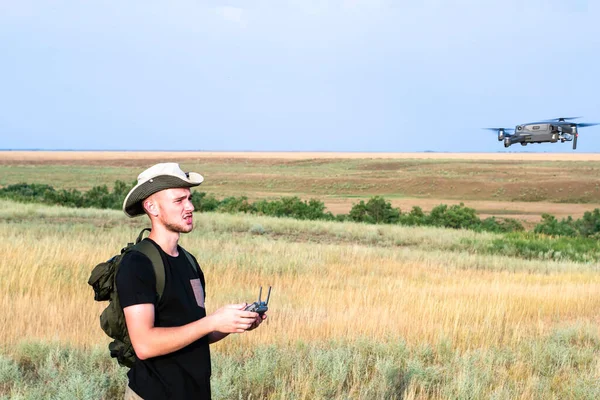 Bir kameraman mavi gökyüzüne karşı bir kuadrokopter fırlatır. Yüksek kalite fotoğraf