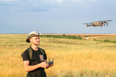 Bir kameraman mavi gökyüzüne karşı bir kuadrokopter fırlatır. Yüksek kalite fotoğraf