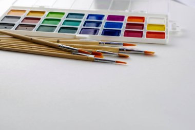 Beyaz arka planda suluboya resimler ve fırçalar. Yüksek kalite fotoğraf