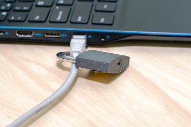 Bilgisayar konsepti veri koruma siber güvenliğine bağlı bir internet kablosundaki asma kilit. Yüksek kalite fotoğraf