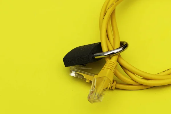 黄色的互联网电缆扭曲成一个环状 闭锁在一个黄色背景信息保护的概念上 高质量的照片 — 图库照片