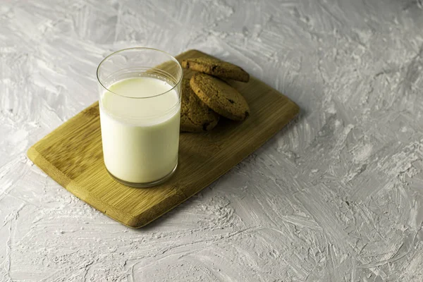Masadaki Tahta Kesme Tahtasının Üzerinde Yulaflı Kurabiyeler Bir Bardak Süt — Stok fotoğraf