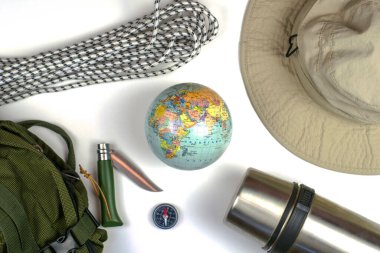 Sırt çantası, pusula, ip, katlanan bıçak termos ve beyaz bir yüzey üzerinde şapka. Yüksek kalite fotoğraf