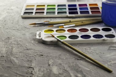 Suluboya fırça ve gri bir yüzey üzerinde bir kavanoz su. Yüksek kalite fotoğraf