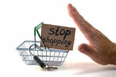 Makul tüketimi satın almayı reddetme kavramı - bir el, asma kilidi olan bir alışveriş sepetini iter ve yazıt beyaz arka planda alışverişi durdurur. Yüksek kalite fotoğraf