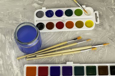 Suluboya fırça ve gri bir yüzey üzerinde bir kavanoz su. Yüksek kalite fotoğraf