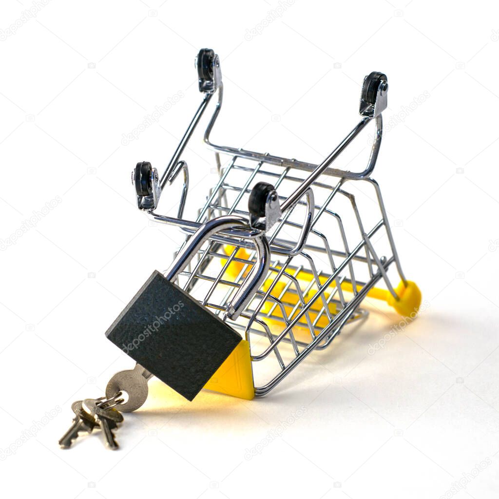 the concept of abandoning the purchase of reasonable consumption is an inverted shopping cart with a padlock on a white background. High quality photo