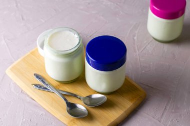 Kesme tahtasında ev yapımı yoğurt ve kaşık kavanozları. Yüksek kalite fotoğraf