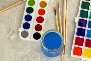 Suluboya fırça ve gri bir yüzey üzerinde bir kavanoz su. Yüksek kalite fotoğraf