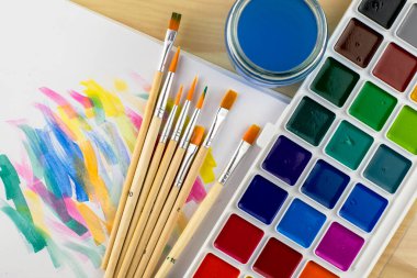 suluboya boya fırça kavanozunu beyaz bir çarşaf üzerinde boya örnekleriyle boyar