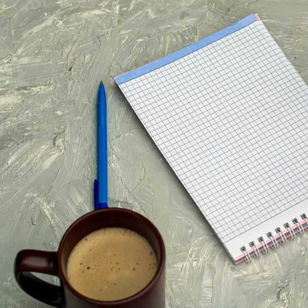 灰色表面上的一杯咖啡卡布奇诺咖啡研磨机记事本和钢笔 高质量的照片 — 图库照片