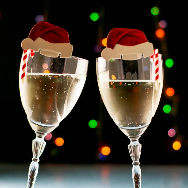 Två Glas Champagne Med Jultomten Hattar Svart Bakgrund Med Ljus — Stockfoto