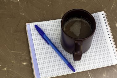 Bir fincan kahve kapuçino kahve öğütücü not defteri ve gri bir yüzeyde dolmakalem. Yüksek kalite fotoğraf