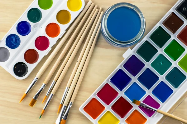 Suluboya fırçalar ve masanın üstünde bir kavanoz su. Yüksek kalite fotoğraf