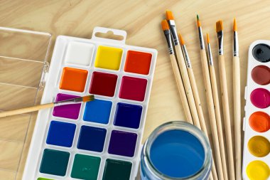 Suluboya fırçalar ve masanın üstünde bir kavanoz su. Yüksek kalite fotoğraf