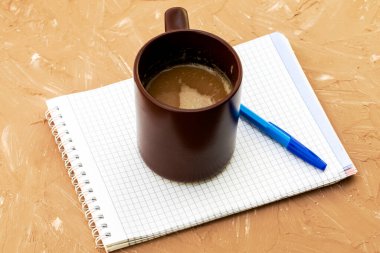 Bir fincan kahve kapuçino kahve öğütücü not defteri ve gri bir yüzeyde dolmakalem. Yüksek kalite fotoğraf