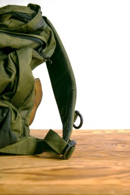 Turist sırt çantası beyaz arka planda ahşap bir zeminde duruyor. Yüksek kalite fotoğraf