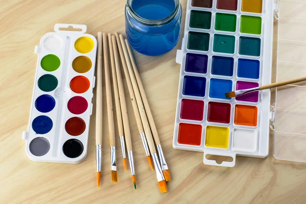 Aquarellfarben Pinsel Und Ein Glas Wasser Auf Dem Tisch Hochwertiges — Stockfoto