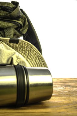 Turist termosu ve beyaz arka planda ahşap zeminde şapka. Yüksek kalite fotoğraf