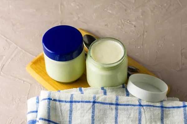 Dosen Mit Hausgemachtem Joghurt Und Löffeln Auf Einem Schneidebrett Neben — Stockfoto