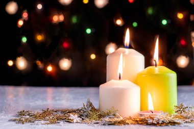 Siyah Noel arkaplanı renkli ışıklar yanan mumlar ve ön planda dekoratif kar taneleri. Yüksek kalite fotoğraf